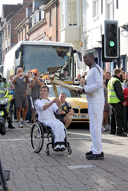 William Copp talikng the flame from legendary Olympic athlete, Michael Johnson in Salisbury