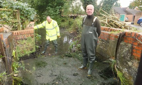 Workmen standing on the dry mill race