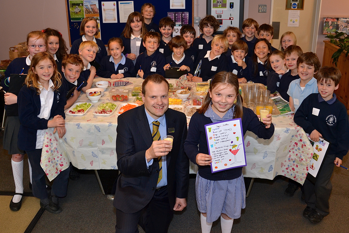 Waitrose store manager Ian Smith with Poppy Childs and children from Preshute School