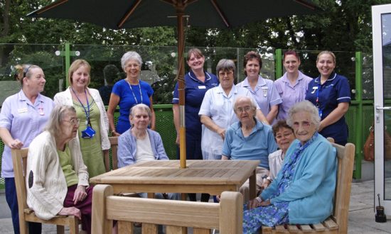 Four Ailesbury patients with their health care support workers (in light blue) and l to r Rosemary Pike, Val Compton (Trustee of The Friends of Savernake Hospital), Sister Emma Bazell and Sister Helen Hodges (in dark blue) .