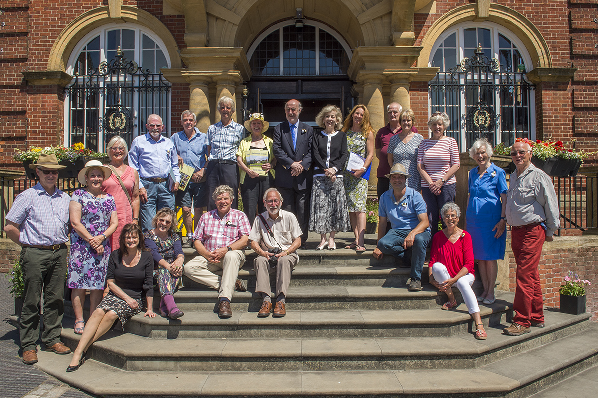 Judges Kim Parish and Tim Elley stand beside Mayor Cllr Noel Barrett-Morton, Mayoress Susan Barrett-Morton and MiB Chair Anne Crowley on the steps of the Town Hall, flanked by the Marlborough in Bloom Committee Members and Volunteers who made this year's entry so strong
