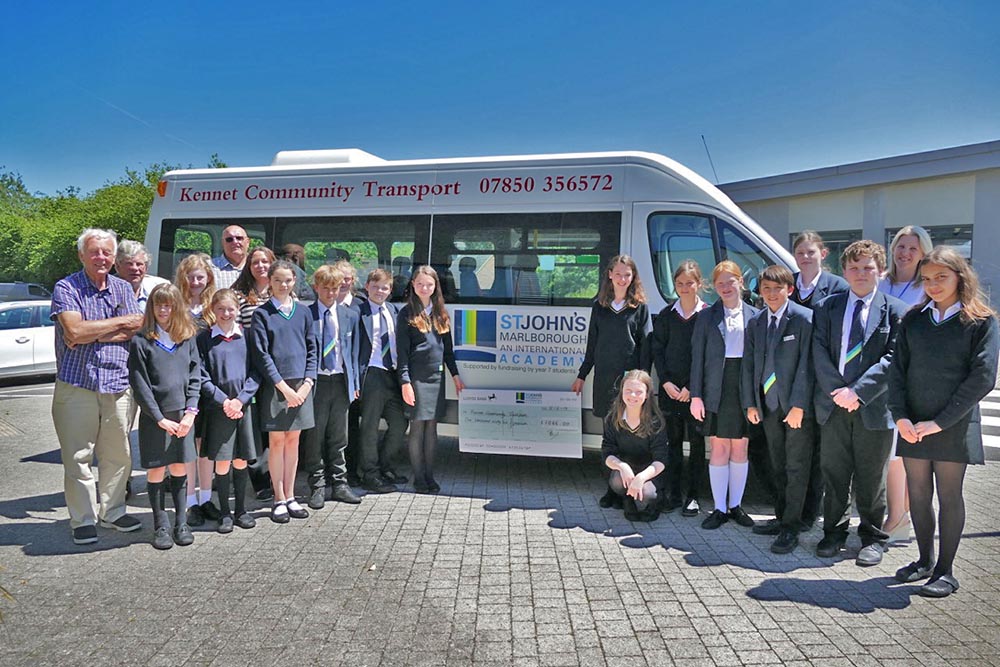 St John’s Year 7 students with the cheque they presented to Kennet Community Transport in front of the KCT minibus which now has the St John’s logo. Adults on left - left to right Roger Hegarty, Alexander Kirk Wilson, Roland Lockey (driver)