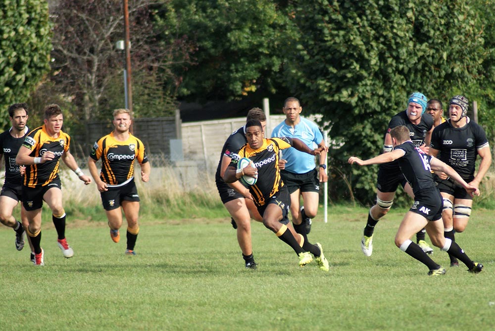 Mitieli Vulikijapani breaks through the Wimborne defence supported by Jake Williams and Ben Fulton