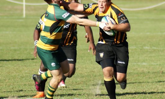 Todd Johnson hands off a Beconsfield opponent whilst being supported by Semisi Rasivo