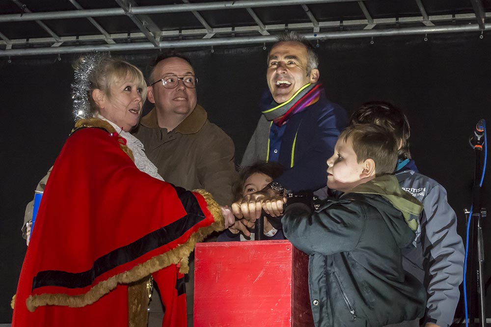 Paul Martin, his three children, Andrew Barnett and Mayor Lisa Farrell all push the plunger down to bring Christmas to Marlborough's High Street