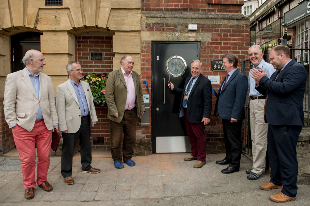Mayor Mervyn Hall formally cuts the ceremonial ribbon and declares the new toilet open
