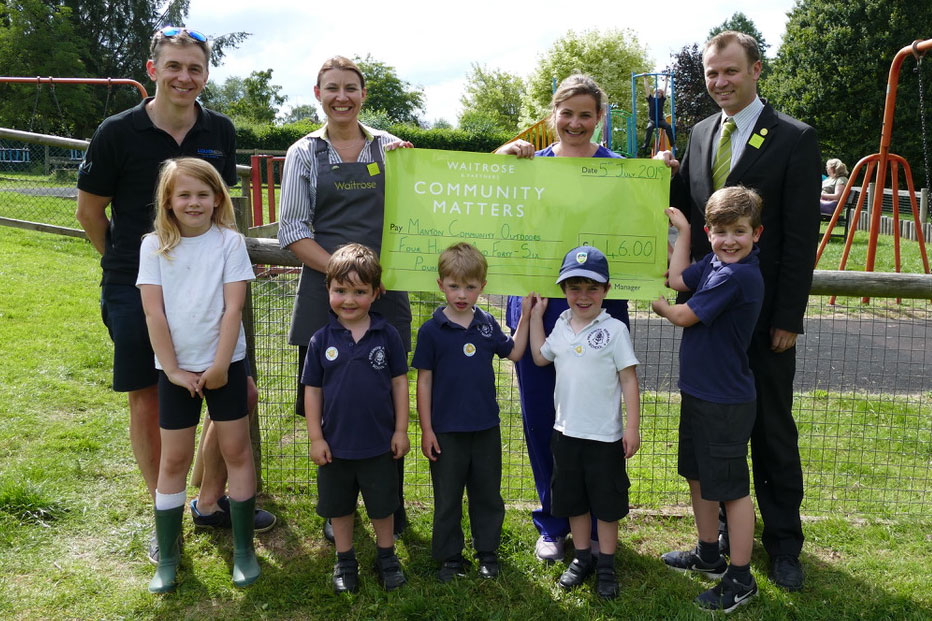 David Bauer and Katie Tilney of Manton Community Outdoors accept the Waitrose cheque from Philip and Lisa on behalf of Manton Community Outdoors